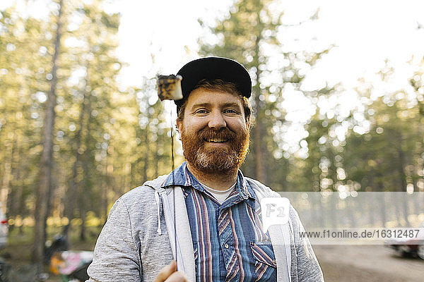 Porträt eines lächelnden Mannes mit gebratenem Marshmallow am Stock  Wasatch Cache National Forest