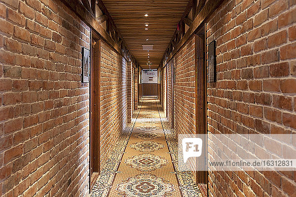 Ein Hotel mit altmodischen Zimmern im Retro-Stil und rustikalen Objekten  Korridor mit gemustertem Teppich  Zimmertüren.