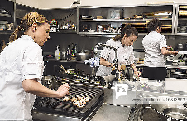 Female chefs preparing food in commercial kitchen at restaurant