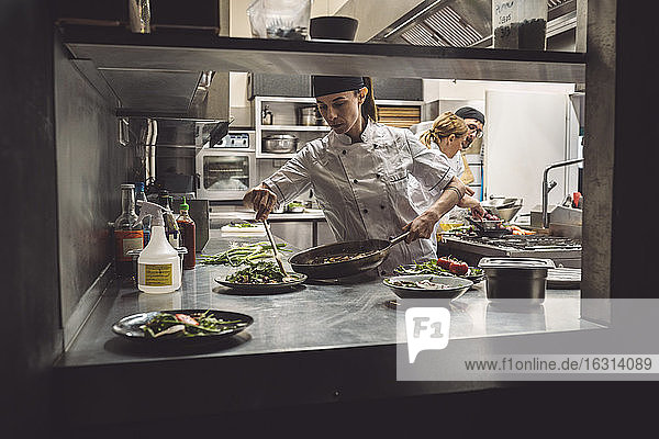 Female chef preparing food in commercial kitchen