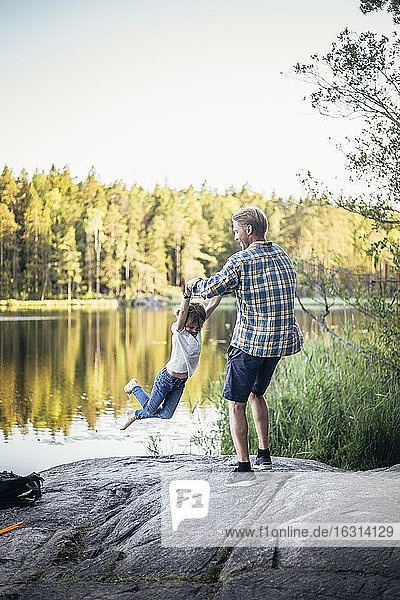 Glücklicher Vater spinnt Tochter am See