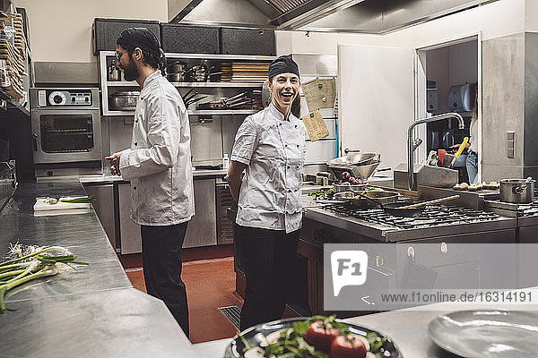 Porträt eines lächelnden Küchenchefs mit Mitarbeiter im Küchenrestaurant