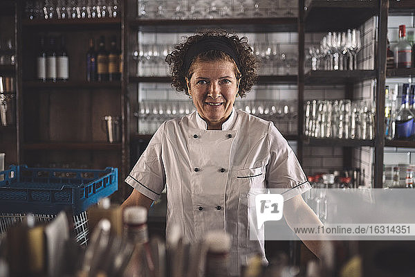 Portrait of smiling female chef in commercial kitchen