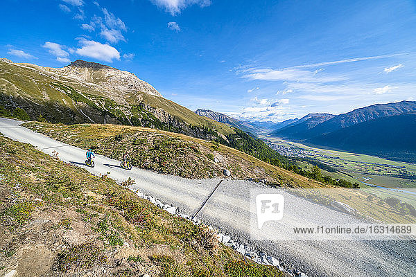 Erhöhter Blick auf Touristen  die mit dem Downhill-Roller auf einem Bergpfad fahren  Celerina  Engadin  Kanton Graubünden  Schweiz  Europa