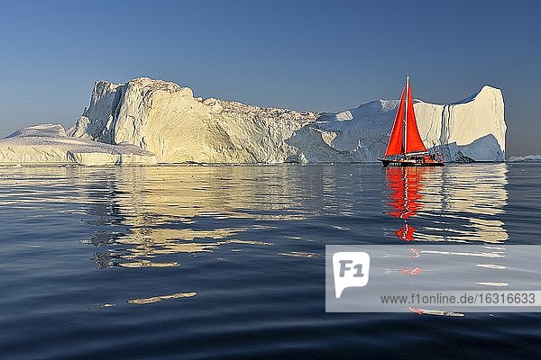 Rotes Segelboot vor Eisbergen, Eisfjord, UNESCO-Weltnaturerbe, Diskobucht, Ilulissat, Westgrönland, Grönland, Nordamerika