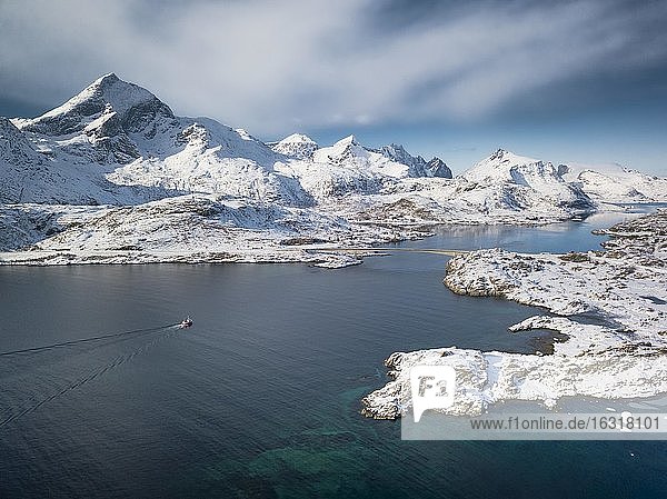 Luftaufnahme  türkiser Fjord mit verschneiten Bergen  Straßenbrücke und kleines Fischerboot  Nordland  Lofoten  Norwegen  Europa
