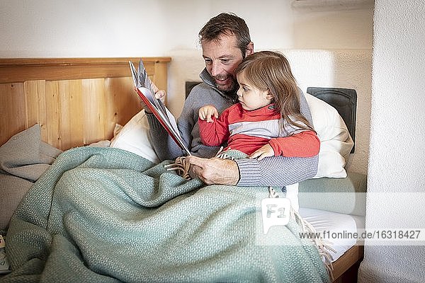 Father reading aloud with daughter  Bavaria  Germany  Europe