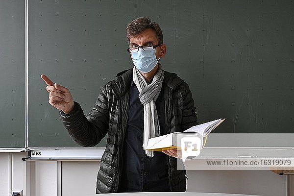 Lehrer mit dicker Winterjacke, Schal und Mundschutzmaske im Präsenzunterricht, Corona-Krise, Stuttgart, Baden-Württemberg, Deutschland, Europa