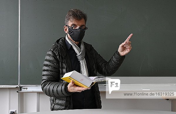 Lehrer mit dicker Winterjacke, Schal und Mundschutzmaske im Präsenzunterricht, Corona-Krise, Stuttgart, Baden-Württemberg, Deutschland, Europa
