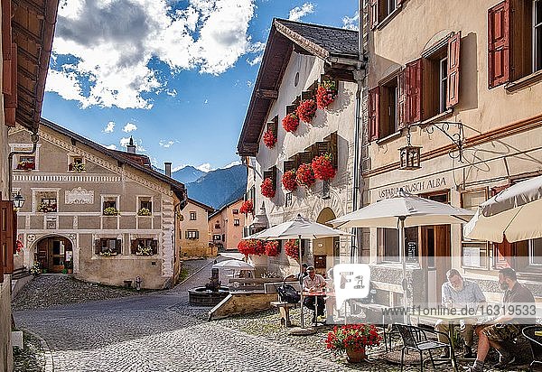 Dorfstrasse mit Restaurantterrasse und typischen Häusern  Bergdorf Guarda  Inntal  Unterengadin  Engadin  Graubünden  Schweiz  Europa