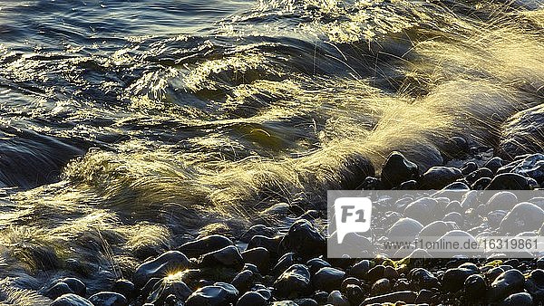 Wellen und Gischt am Strand bei Sonnenaufgang  Wellenbewegungen am Fuße der Kreidefelsen  Ostsee  Saßnitz  Rügen  Nationalpark Jasmund  Mecklenburg-Vorpommern  Deutschland  Europa