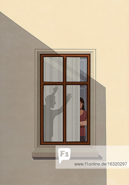 Schatten eines wütenden Mannes  der eine Frau im Wohnungsfenster anspricht