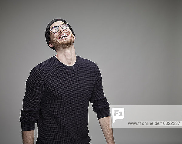 Porträt eines lachenden Mannes mit Wollmütze und Brille