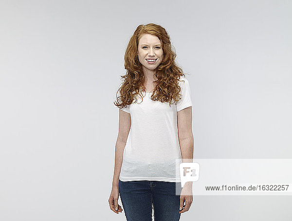 Porträt einer lächelnden jungen Frau vor einem weißen Hintergrund