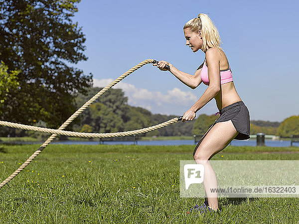 Germany  Young woman doing sports with ropes