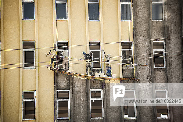 Äthiopien  Addis Abeba  Vier Männer streichen Hausfassade