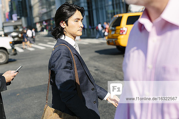 USA  New York City  Geschäftsmann beim Überqueren der Straße in Manhattan