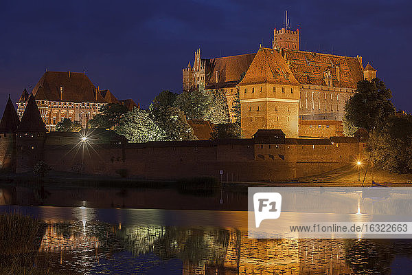 Poland Malbork Castle at River Nogat at night