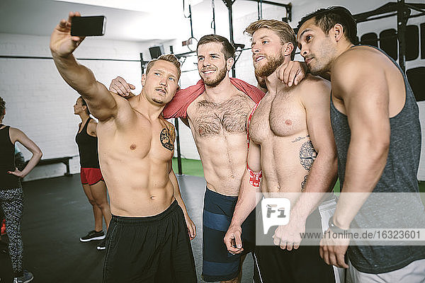 Vier Sportler im Fitnessstudio machen ein Selfie
