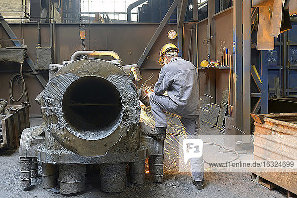 Worker using buzz saw in a foundry