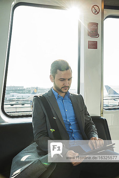 Deutschland  Frankfurt  junger Geschäftsmann im Bus am Flughafen