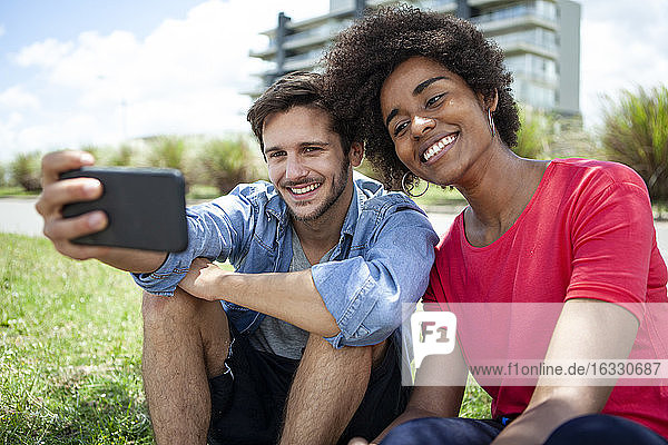 Junges Paar macht Selfie mit Smartphone im Park