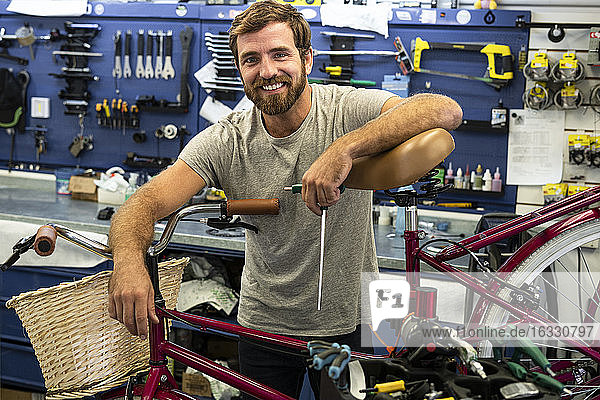Mechanic leaning on bicycle