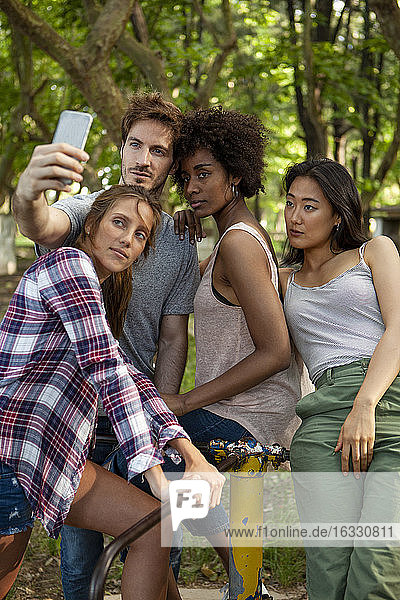 Junge Freunde stehen auf der alten Plattform des Karussells und machen ein Selfie