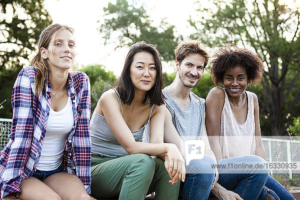 Eine Gruppe junger Freunde sitzt im Park zusammen