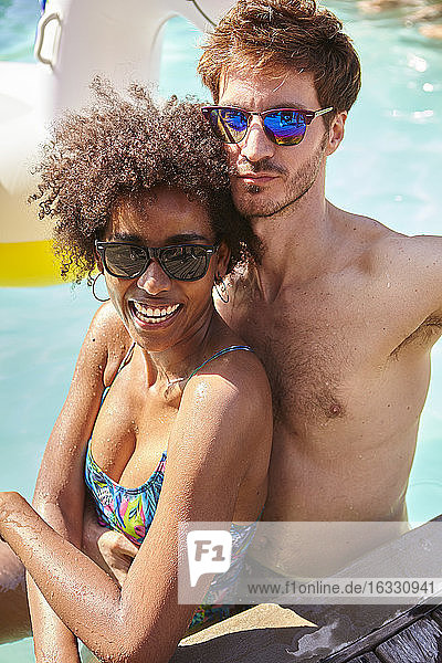 Junges Paar umarmt sich im Schwimmbad
