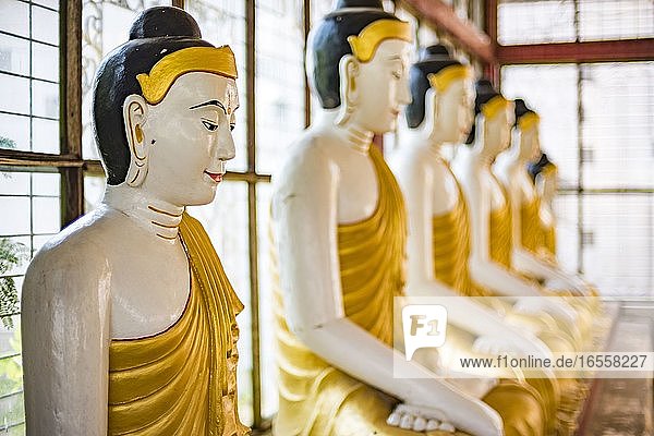 Reihe großer goldener Buddha-Statuen in Lotus-Stellung  in einem Tempel in Yangon (Rangun)  Myanmar (Burma)