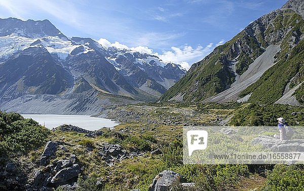 Man on Rock with Glaciers and snow-topped mountains and lake  Aoraki/Mount Cook National Park  South Island  New Zealand