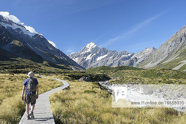 Mann auf Wanderweg mit Gletschern und schneebedecktem Berg  Hooker Track  Aoraki/Mount Cook National Park  Südinsel  Neuseeland