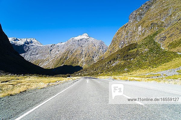 Straße auf der Fahrt von Te Anau nach Milford Sound  Fiordland  Südinsel  Neuseeland. Die Fahrt von Queenstown zum Milford Sound dauert etwa 4 Stunden  so dass ein Zwischenstopp in Te Anau auf jeden Fall ratsam ist. Außerdem kann man so den Touristenmassen entgehen  wenn man frühmorgens anreist.