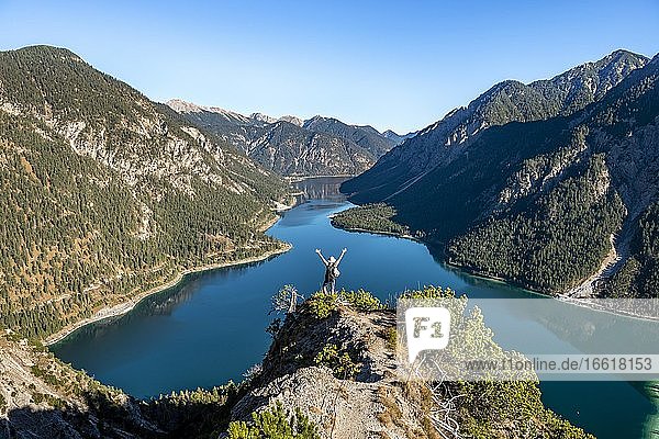 Hiker stretches out his arms in the air  view of Plansee  Schönjöchl in the background  hike to Schrofennas  Ammergau Alps  Reutte district  Tyrol  Austria  Europe