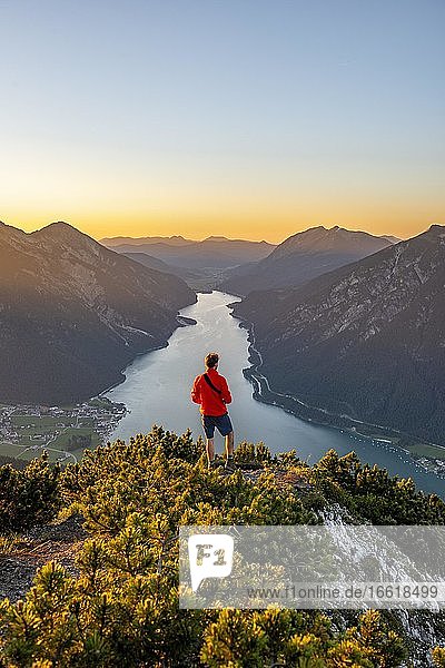 Sunset  young man looking over mountain landscape  view from the top of Bärenkopf to the Achensee  on the left Seebergspitze and Seekarspitze  Tyrol  Austria  Europe