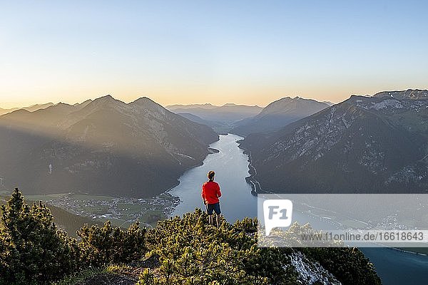 Sonnenuntergang  junger Mann blickt über Berglandschaft  Ausblick vom Gipfel des Bärenkopf auf den Achensee  links Seebergspitze und Seekarspitze  Tirol  Österreich  Europa
