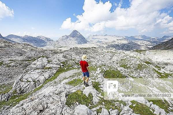 Wanderer blickt in die Ferne  Landschaft aus ausgewaschenen Karststeinfelsen  Funtenseetauern  Steinernes Meer  Nationalpark Berchtesgaden  Berchtesgadener Land  Oberbayern  Bayern  Deutschland  Europa
