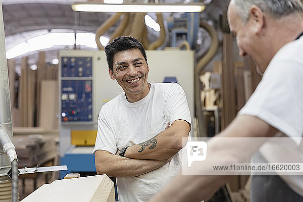 Lächelnde Mitarbeiter bei der gemeinsamen Arbeit in der Werkstatt