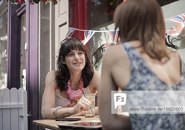 Woman talking with female friend while sitting at pub