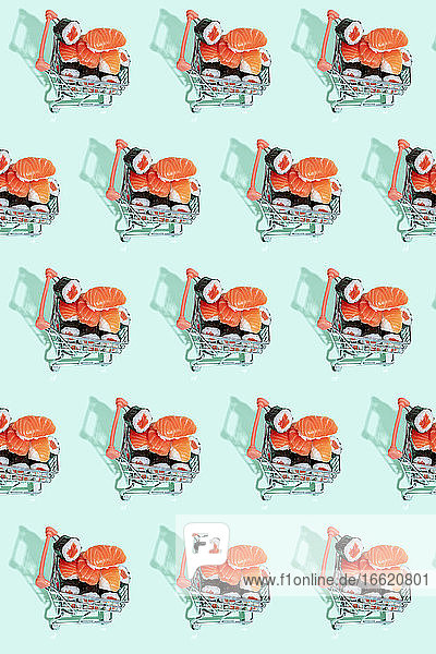 Fresh Japanese salmon sushi nigiri in shopping carts on colored background