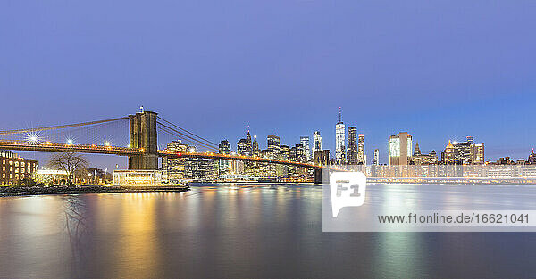 USA  New York  New York City  Brooklyn Bridge und Skyline von Manhattan bei Nacht beleuchtet