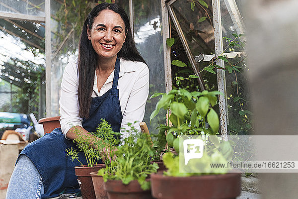 Smiling woman sitting in garden shed