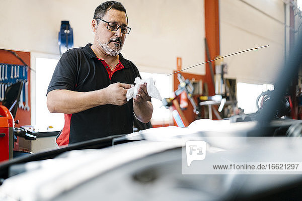 Männlicher Mechaniker repariert Auto in einer Autowerkstatt