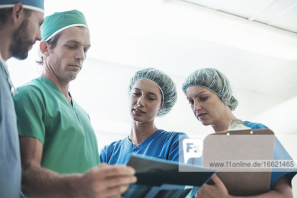 Ein Team von Chirurgen diskutiert über ein medizinisches Röntgenbild im Krankenhaus