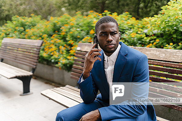 Young male entrepreneur talking on mobile phone while looking away in city