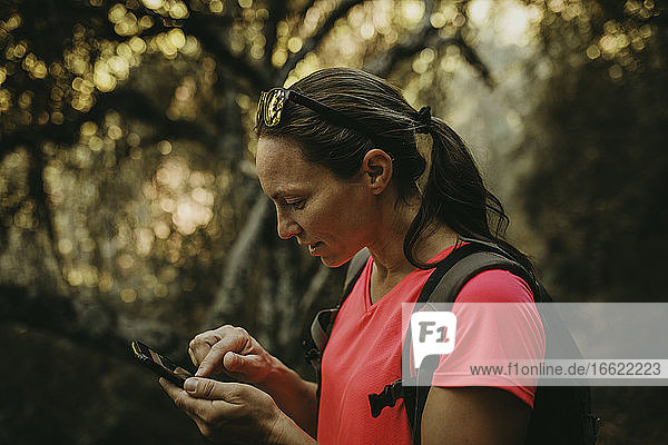 Wanderer  der ein Mobiltelefon benutzt  während er in der Sierra De Hornachuelos  Cordoba  Spanien steht