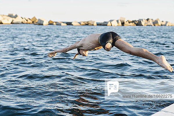 Behinderter Mann taucht an einem sonnigen Tag ins Wasser