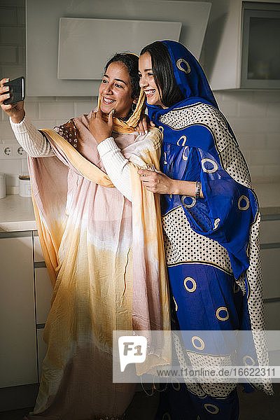 Junge Freunde machen ein Selfie mit ihrem Smartphone  während sie in der Küche stehen