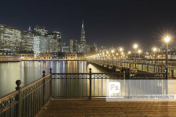 Pier 7 with illuminated building in background at San Francisco  California  USA